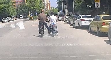 Bisiklet ile motosikleti ayağı ile iterek ilerletti