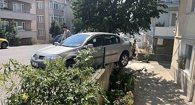 El frenini çekmeyi unuttu, otomobil bahçe duvarında asılı kaldı