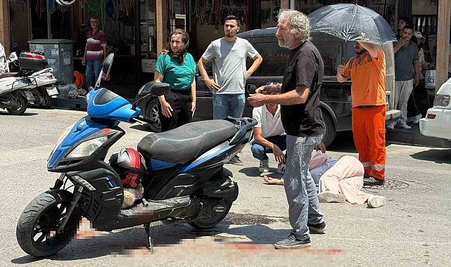 Kazada yaralanan genç kadına esnaftan şemsiyeli destek