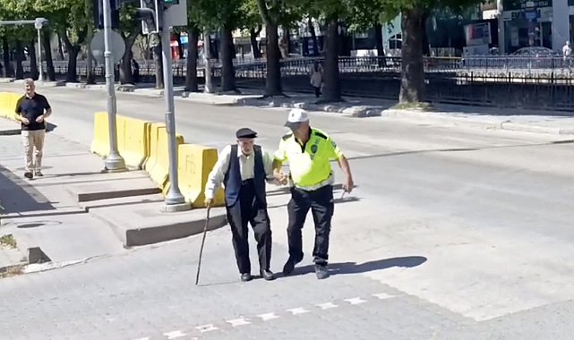 Trafik polisinin yürümekte zorlanan yaşlı adama yardımı yürekleri ısıttı